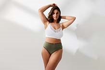 Femme en soutien-gorge appuyée contre un cadre de porte